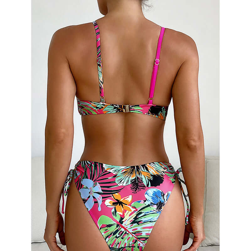 Back view of a woman in a pink tropical print cheeky bikini showing a stylish swimwear design.