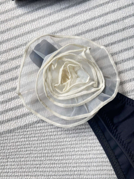 Close-up of a white sheer mesh rose flower embellishment on a black bikini, perfect for sexy lingerie styles.